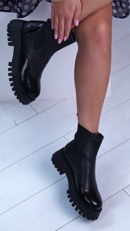 feet of woman posing shoes. girl fit legs in black boots. vertical video