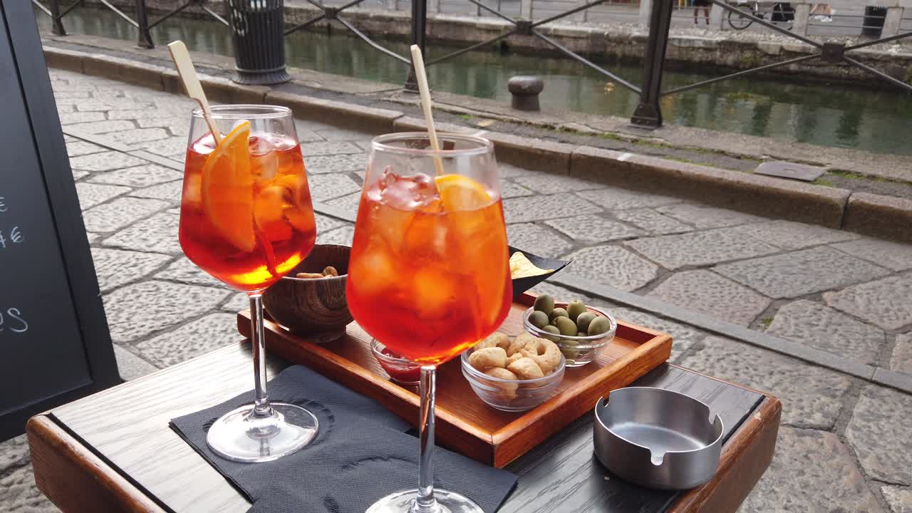 Aperol close up at Italian travel spritz drinks on a restaurant table by the river