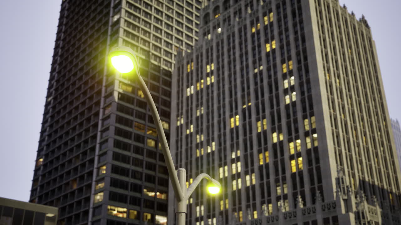 City skyline with modern buildings and illuminated street lamps at dusk