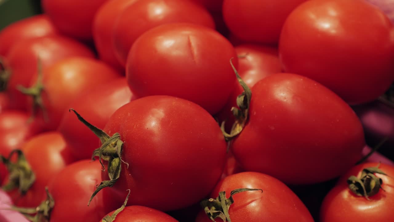 A detailed picture of vibrant, ripe red tomatoes with green stems, ideal for cooking and culinary purposes