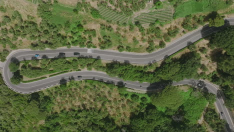 imágenes aéreas de arriba hacia abajo de automóviles conduciendo hacia arriba y hacia abajo por un camino ventoso en la costa de amalfi
