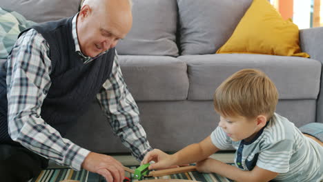 grandfather and grandson playing with toy train