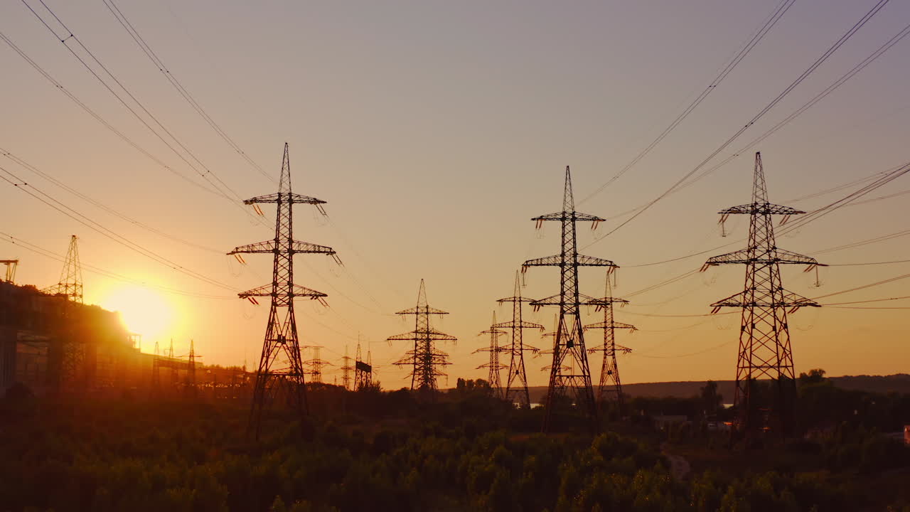 Wire electrical energy at sunset. High voltage electricity pole at sunset