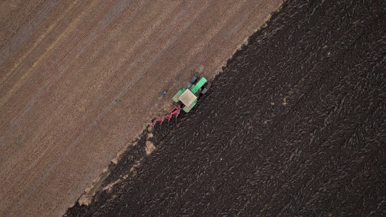 Tractor plowing a field from an aerial perspective