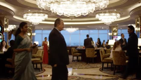 elegant evening in a luxurious lounge: a bustling atmosphere where elegantly dressed guests enjoy fine dining and socializing under sparkling chandeliers.