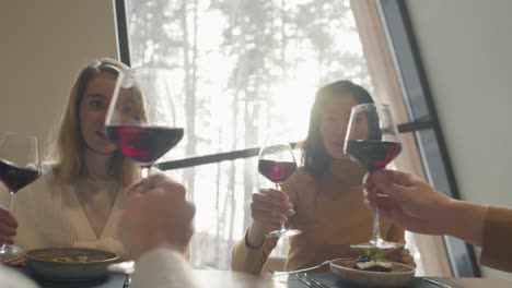 grupo de amigos brindando con vino tinto en un restaurante