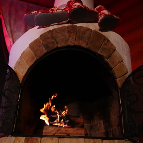 warm fireplace at christmas holidays. wood burning in a beautiful brick fireplace. cosy atmosphere at home. home comfort in winter