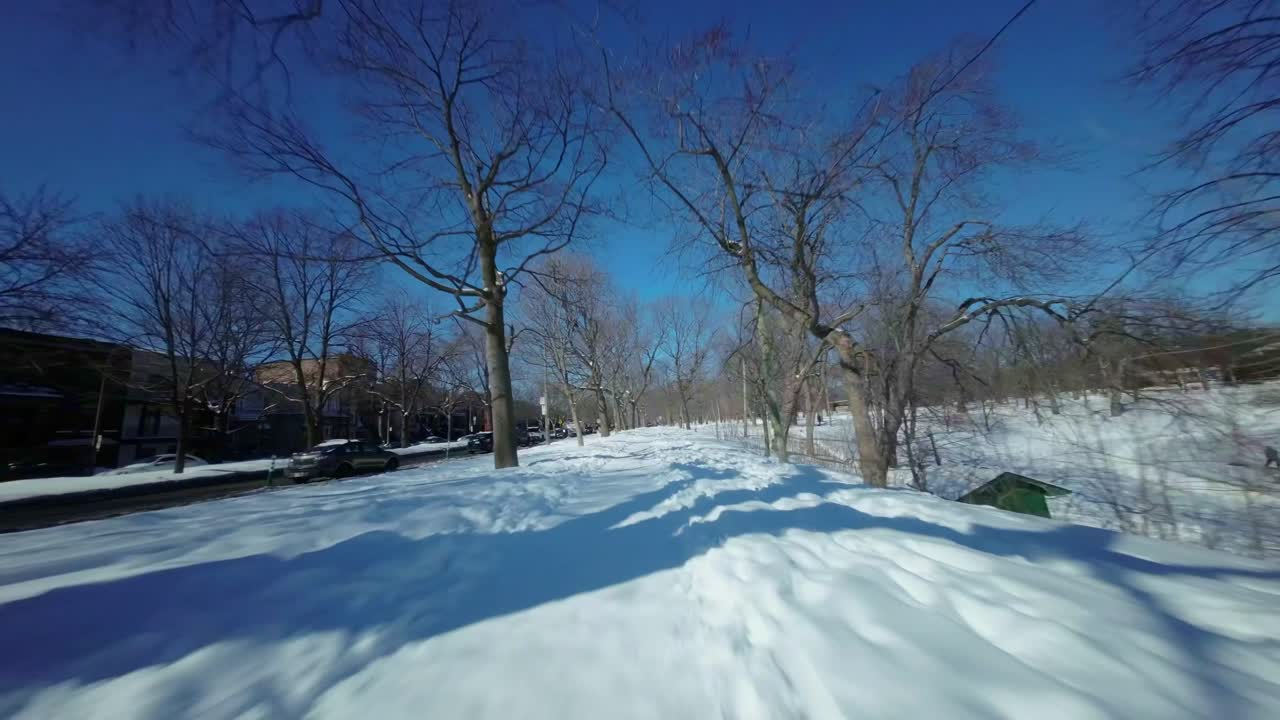 몬트리올의 라 폰테인 공원 위를 낮게 날아다니는 fpv 드론, 겨울 풍경을 보여줍니다.