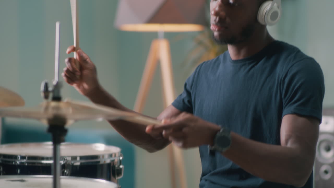 hombre tocando la batería en casa