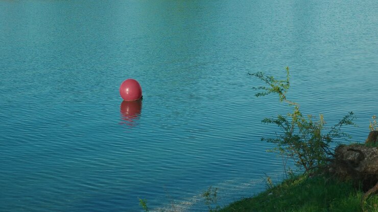 single red buoy floating on the calm blue waters of Jarun Lake in Zagreb, Croatia