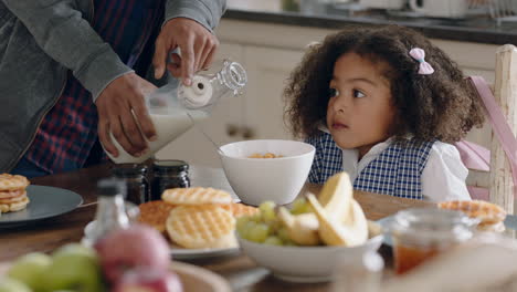 happy little girl eating cereal for breakfast in kitchen getting ready for school father caring for daughter enjoying fatherhood at home