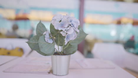 light purple hydrangea in a metal pot on a white table