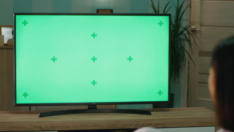person watching a tv with green screen