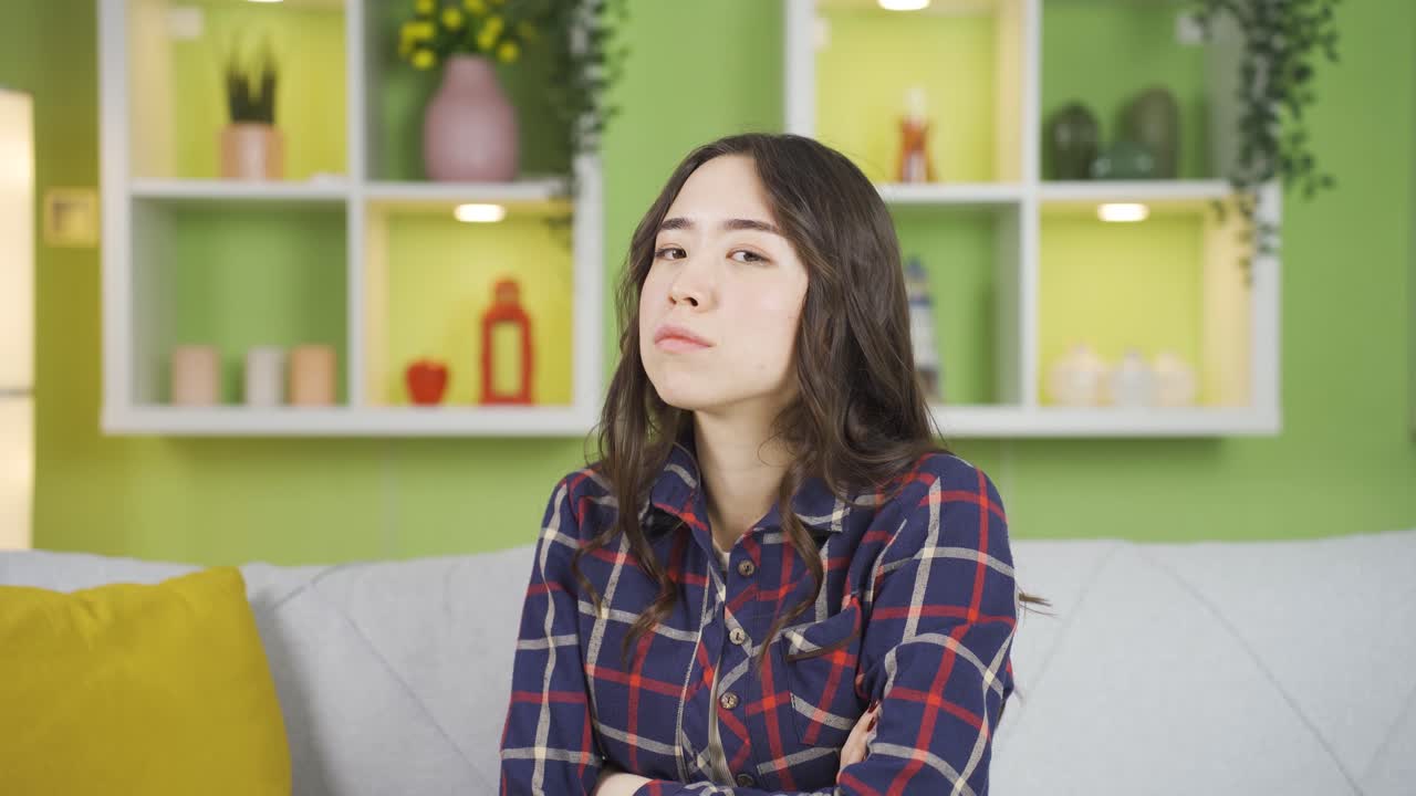 젊은 아시아 여성이 화를 내며 카메라를 쳐다보며 분노를 표현하고 있습니다.