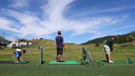 two people practicing golf swings outdoors