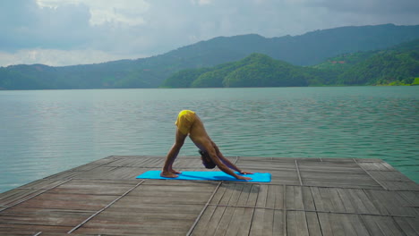 Genießen-Sie-Die-Gelassenheit,-Während-Ein-Mann-Auf-Einer-Terrasse-Mit-Blick-Auf-Den-Begnas-See-In-Pokhara,-Nepal,-Yoga-Praktiziert-Und-Dabei-Beruhigende-Bewegungen-Mit-Atemberaubenden-Ausblicken-Zu-Einem-Unvergesslichen-Erlebnis-Verbindet