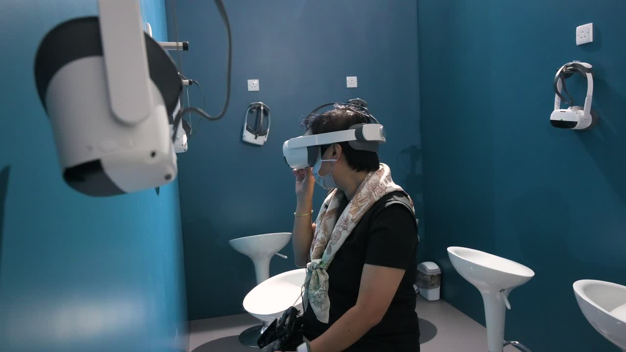 A Chinese visitor wears and tries a virtual reality headset to experience an immersive adventure simulator