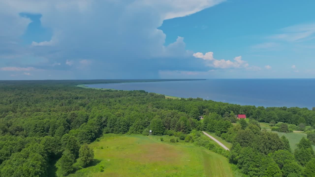 Flying over rural coastal area with stormclouds in the background