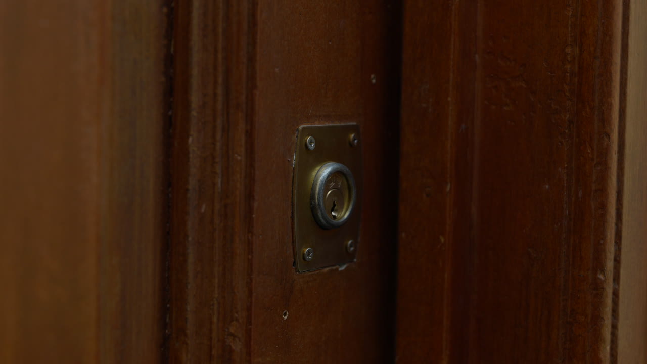 오래 된 목조 황동 문 열쇠 구멍 잠금 키 잠금을 손에 가까이
