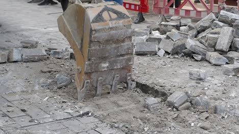 excavator demolishing pavement