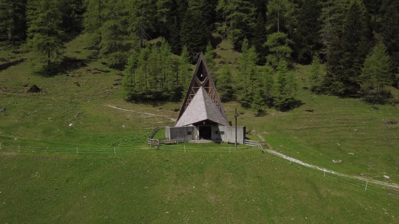 A serene mountain church nestled in Axamer Lizum, captured from above with stunning mountain backdrops and surrounding nature