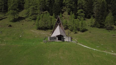 a serene mountain church nestled in axamer lizum, captured from above with stunning mountain backdrops and surrounding nature