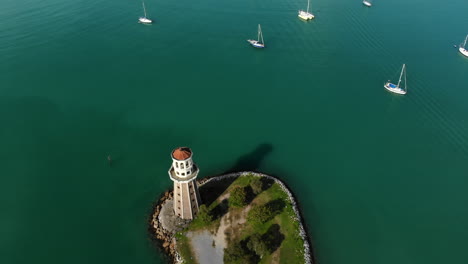 vista aérea revelada del anclaje de yates de lujo, faro, agua turquesa