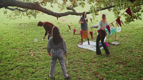 friends playing badminton and having a picnic in the park