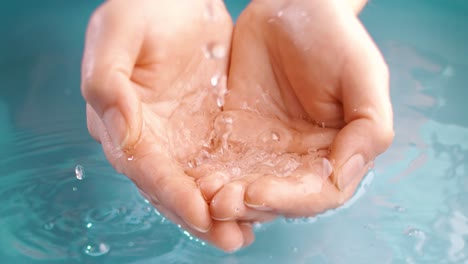 clean drinking water flows in the palms of the woman hands. shot on super slow motion camera 1000 fps.