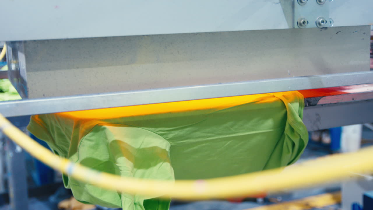 Bright shirt dries under heat press, finalizing vibrant screen print design