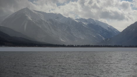 Vista-Diurna-Del-Lago-En-Lagos-Gemelos-Con-Montañas-Nevadas-Al-Fondo-Y-Olas-Visibles-Del-Lago