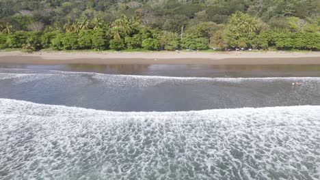 vista aérea de las olas rompiendo el zapato en la playa dominical en costa rica, seguimiento