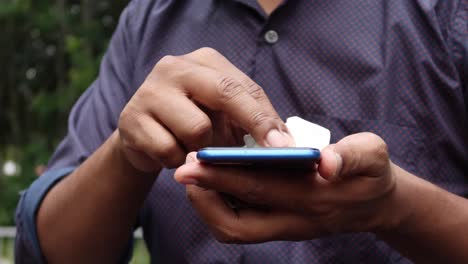 Mano-De-Hombre-Limpiando-La-Pantalla-Del-Teléfono-Móvil.