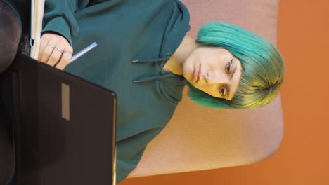 vertical video of young woman looking at laptop is unmotivated and bored.