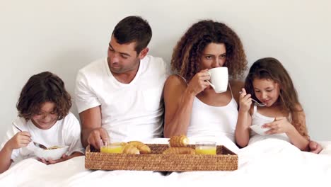 Cute-family-having-breakfast-in-bed