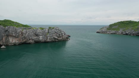 Flying-towards-Orion-boat-anchored-in-front-of-Koh-Wao-island,-Ang-Thong-Park