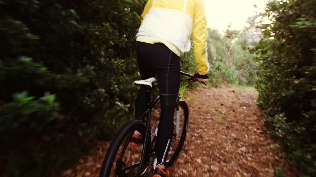 Ciclista di mountain bike uomo che pedala nel bosco