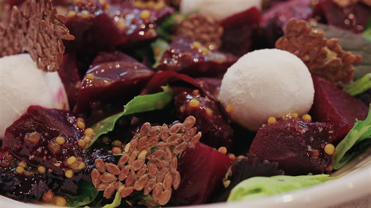 Nahaufnahme eines Rote-Bete-Salats mit cremigem Käse, Kernen und Salatgrün