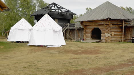 patio de un asentamiento medieval con tiendas de campaña y puertas de madera