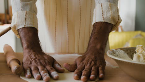 man making flatbread in home kitchen
