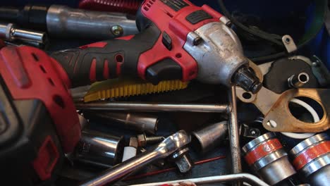 cordless impact wrench seen with a ratcheting wrench and other tools on a steel table, auto shop and tools, bangkok, thailand