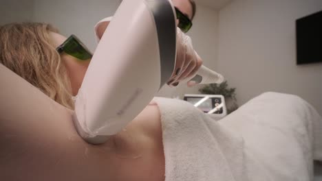 área de la axila de la mujer durante el procedimiento de depilación láser en la clínica de cosmetología moderna. concepto de belleza femenina, cosmetología, depilación