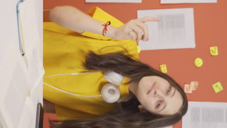 video vertical de una niña alegre bailando en casa y sintiéndose feliz.