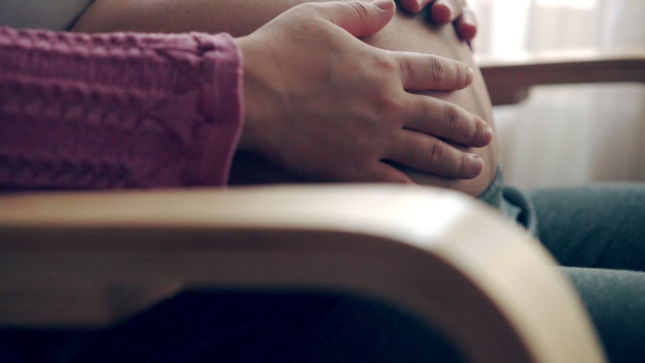 행복한 임신한 여성과 집에서 아기를 기대하고 있습니다.