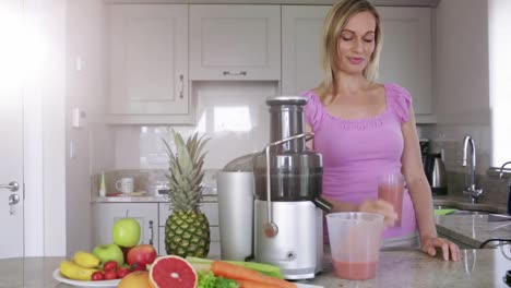 blonde pouring fresh fruit and vegetable juice