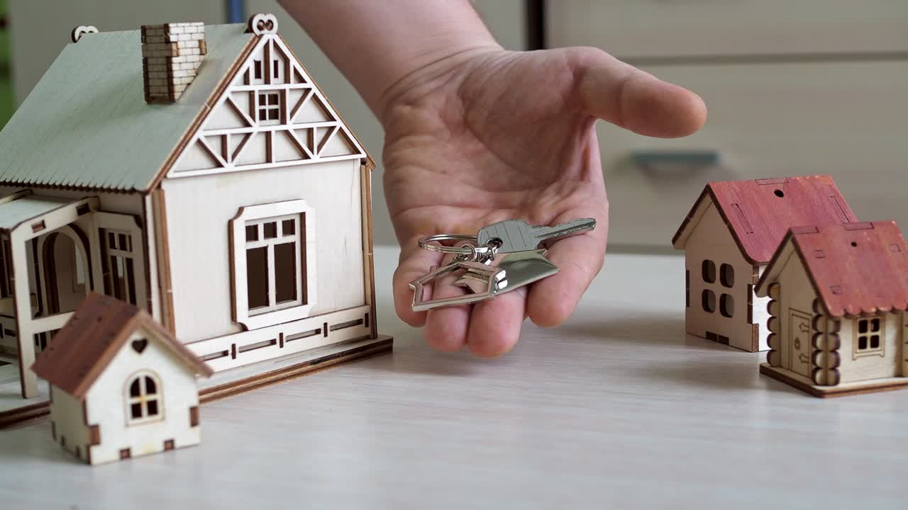 llaverillo con las llaves del nuevo apartamento en la mano. compra de bienes raíces. hermosas llaves para el nuevo edificio