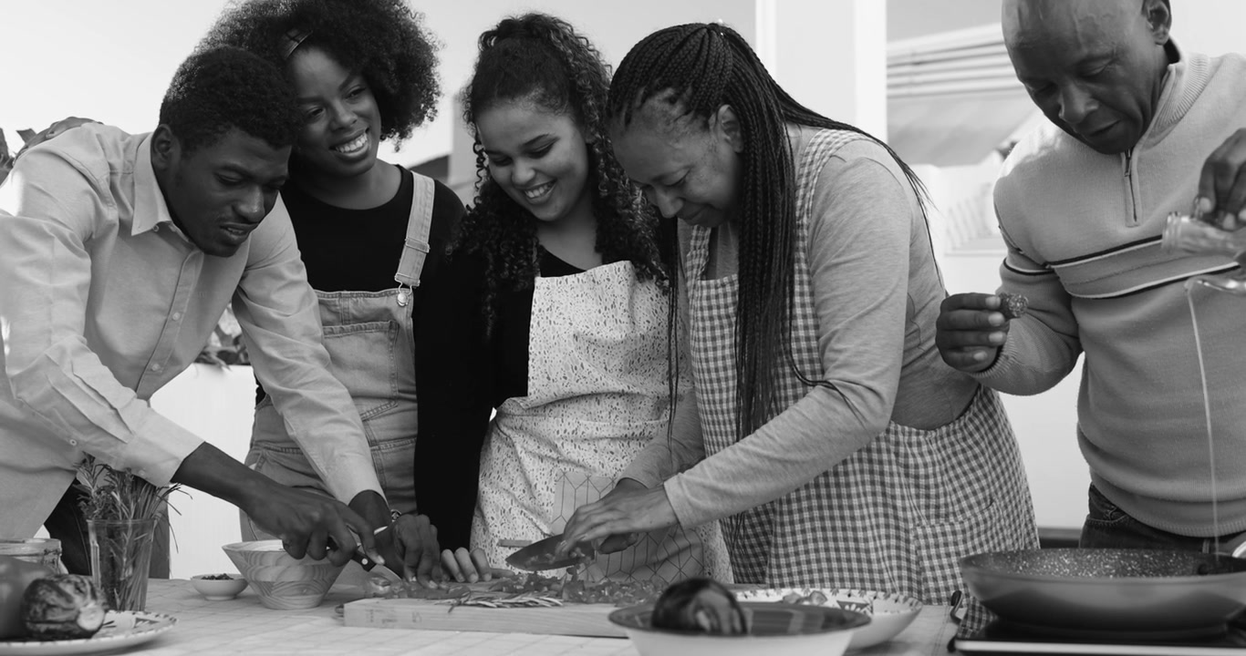 Famiglia africana multigenerazionale felice che cucina insieme