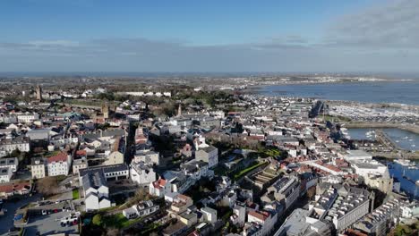 St-Peter-Port-Guernsey-Ocupada-Revelación-Aérea-De-La-Ciudad-Sobre-El-Puerto-Mirando-Al-Norte-Y-Retrocediendo-Hacia-El-Sur-Para-Revelar-Los-Edificios-Y-La-Perspectiva-De-La-Ciudad-En-Un-Día-Soleado