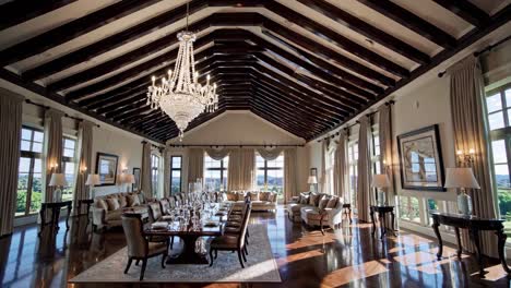 luxurious dining room with a long table, elegant chandelier, and large windows