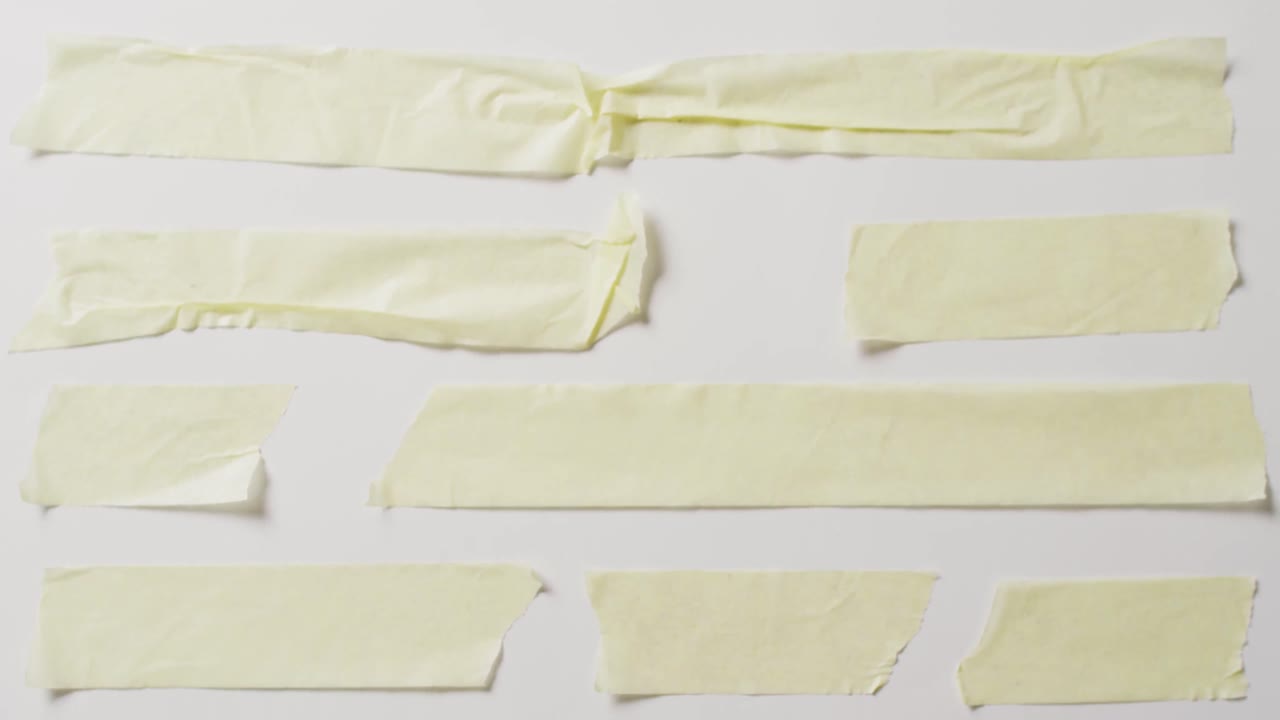 video de un primer plano de varias piezas rasgadas de papel amarillo con espacio de copia en un fondo blanco